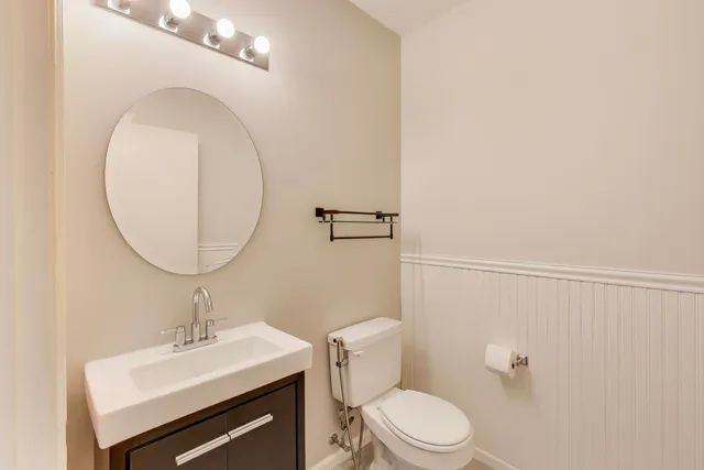 a bathroom with a sink a toilet and a mirror