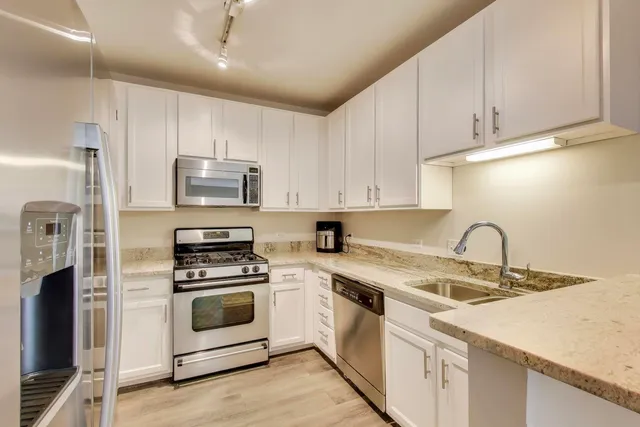 a kitchen with appliances a sink and cabinets