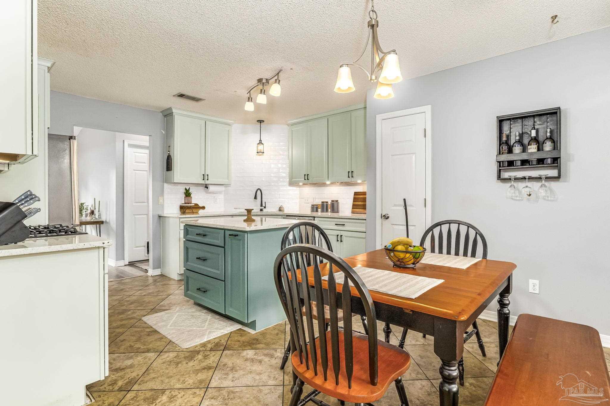 2000 Winners Circle Cantonment, FL 32533 - Photo 17 of 59 a kitchen with a dining table chairs and refrigerator