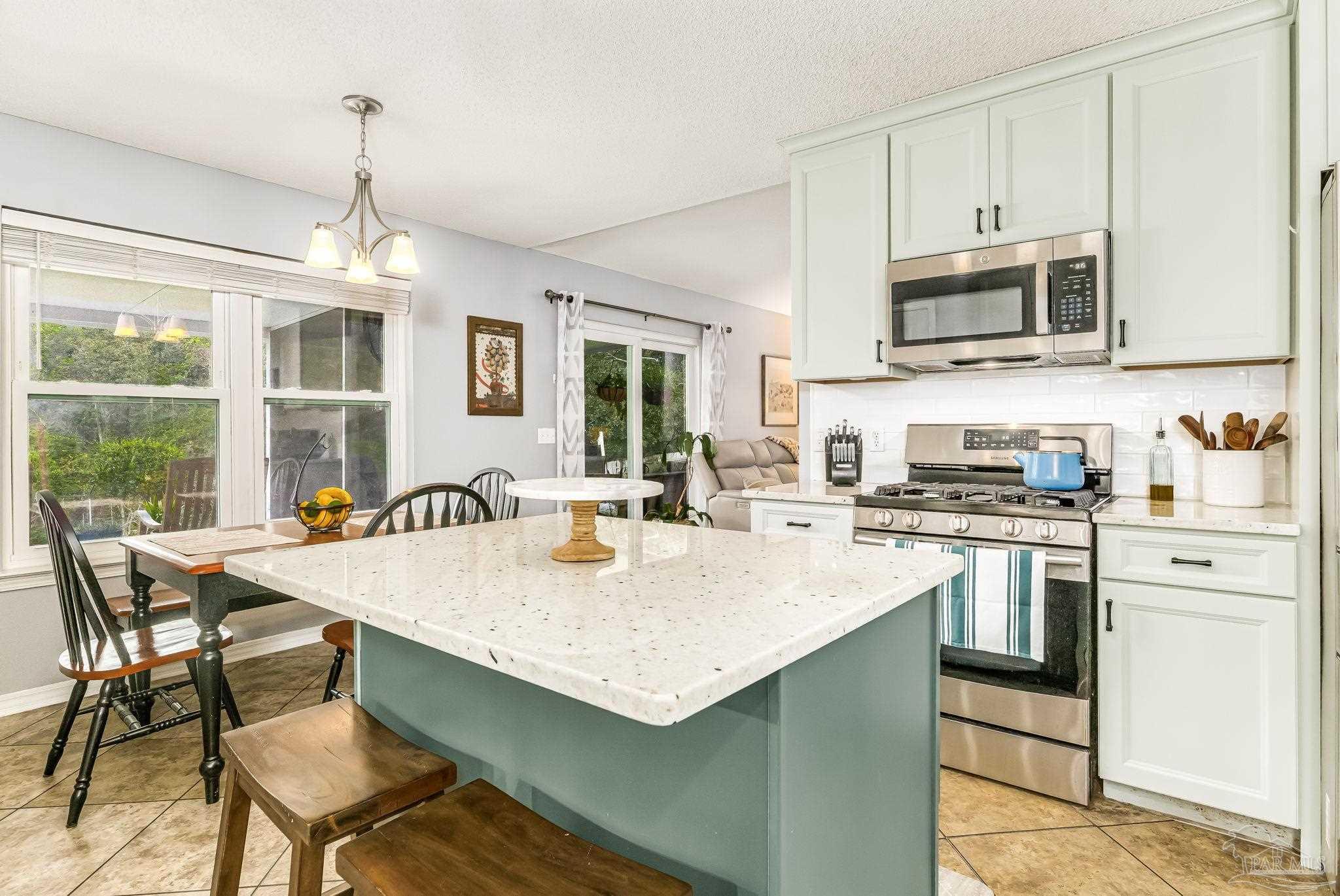 2000 Winners Circle Cantonment, FL 32533 - Photo 20 of 59 a kitchen with stainless steel appliances granite countertop a stove a sink dishwasher a stove and a refrigerator with wooden floor