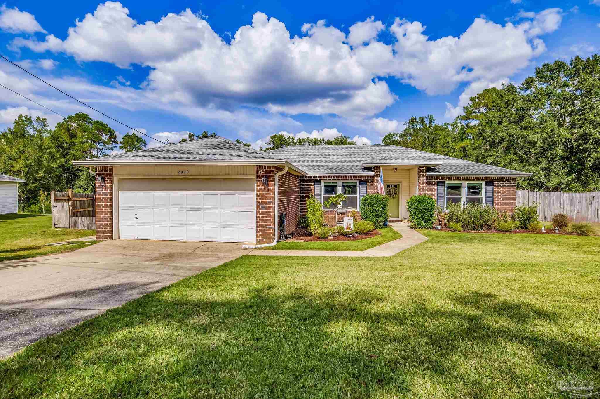 2000 Winners Circle Cantonment, FL 32533 - Photo 2 of 59 a front view of a house with yard and green space