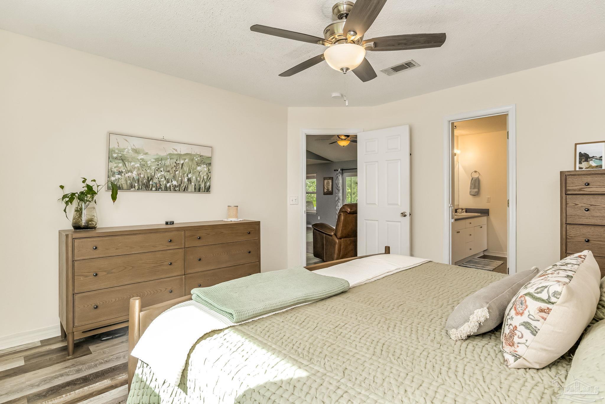 2000 Winners Circle Cantonment, FL 32533 - Photo 25 of 59 a bedroom with a bed and a chandelier