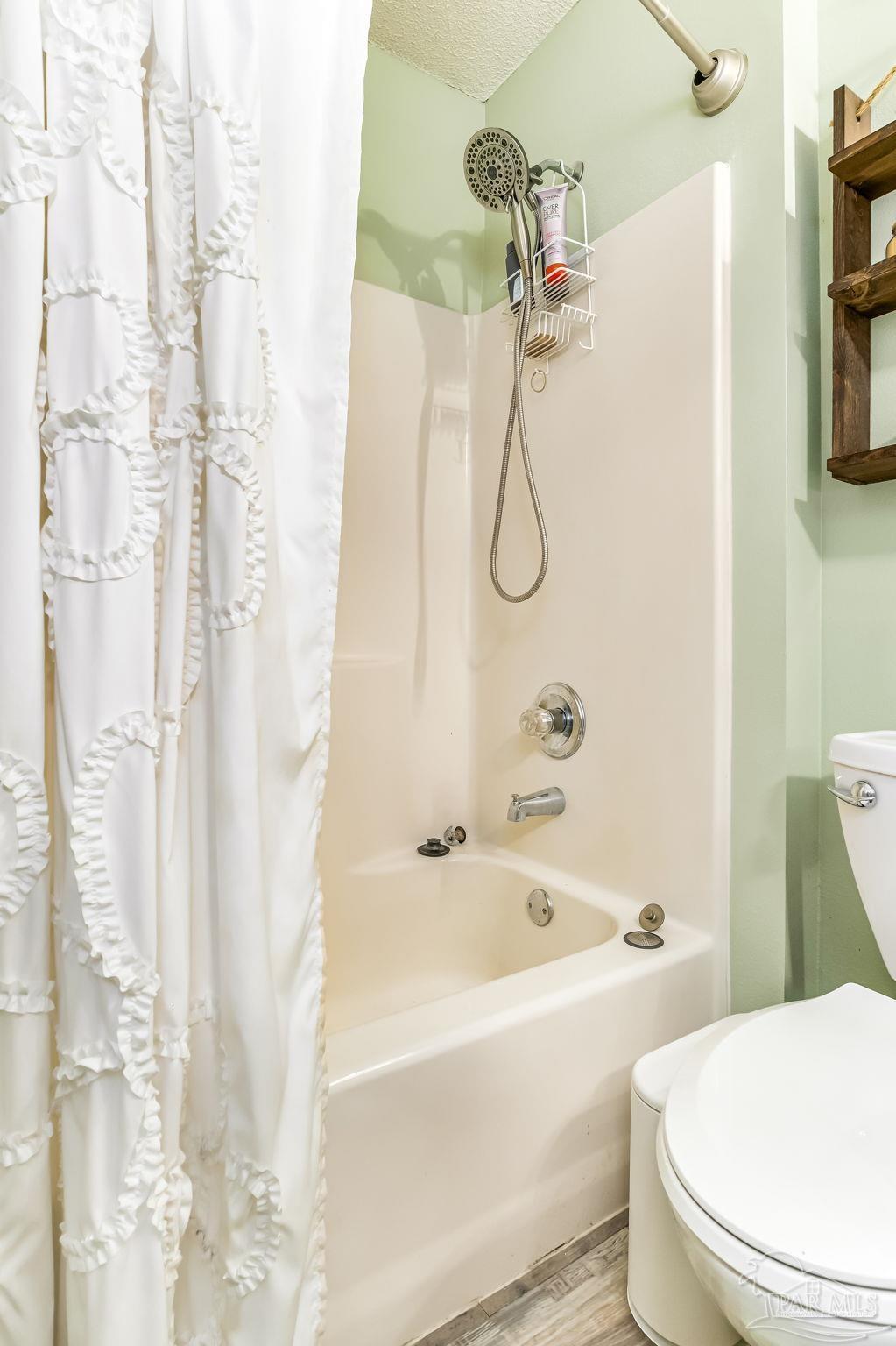 2000 Winners Circle Cantonment, FL 32533 - Photo 40 of 59 a white bath tub sitting next to a white toilet and a shower curtain