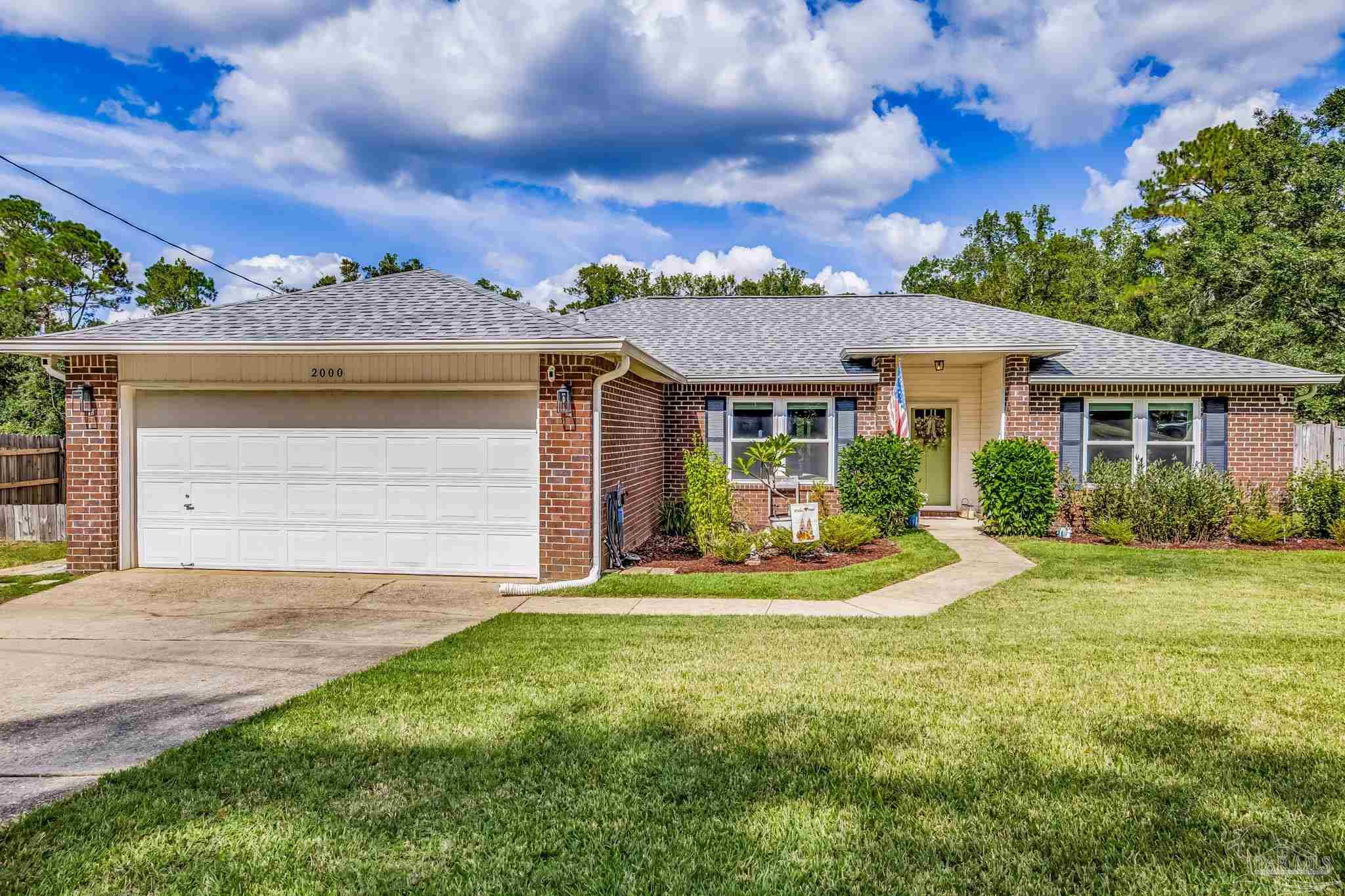 2000 Winners Circle Cantonment, FL 32533 - Photo 4 of 59 a front view of a house with a garden and pathway