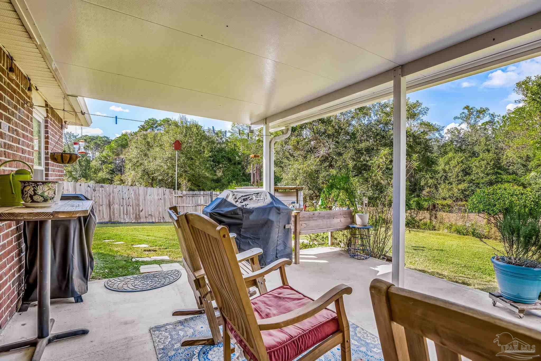 2000 Winners Circle Cantonment, FL 32533 - Photo 46 of 59 a view of a patio with table and chairs potted plants with wooden floor and fence