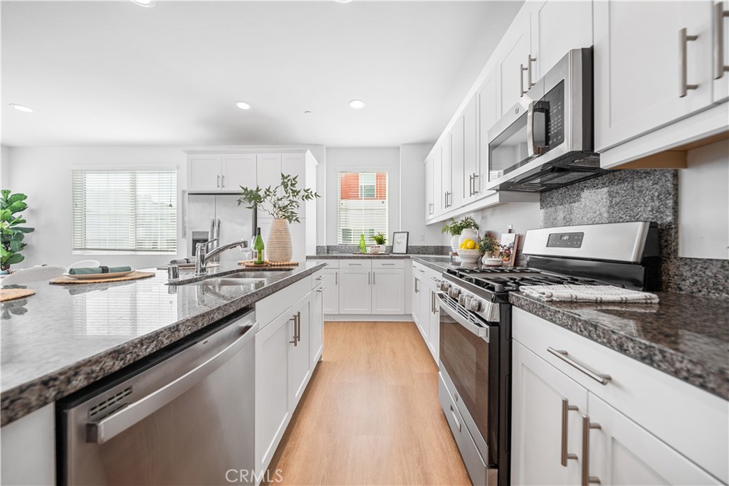 11016 Getaway Drive Rancho Cucamonga, CA 91730 - Photo 17 of 44 a large kitchen with stainless steel appliances granite countertop a stove a sink and a microwave