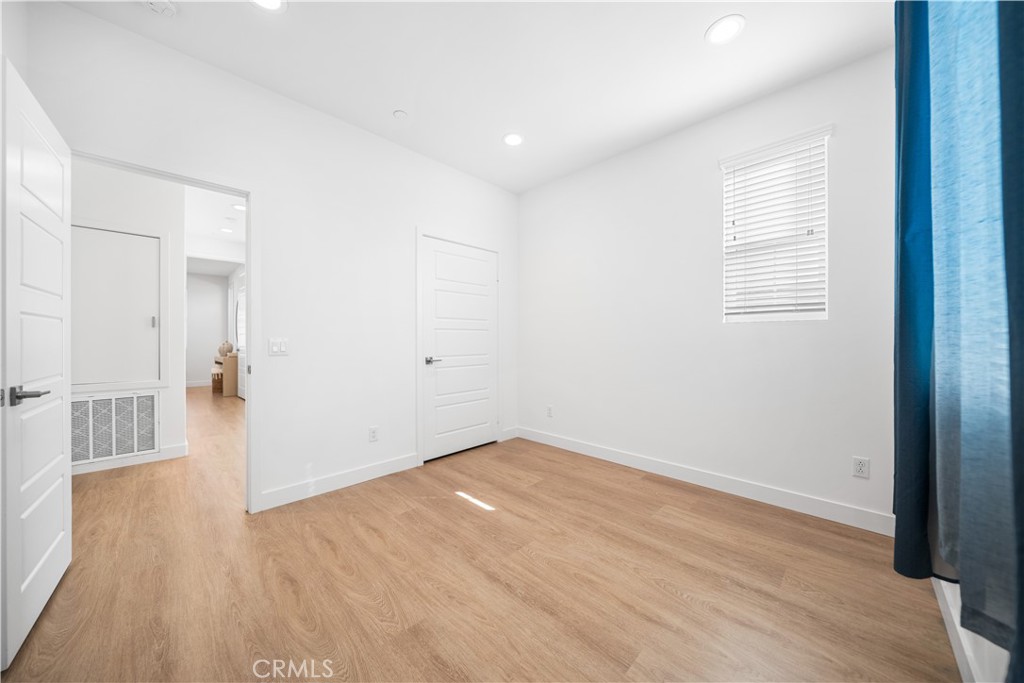 11016 Getaway Drive Rancho Cucamonga, CA 91730 - Photo 31 of 44 an empty room with wooden floor and windows