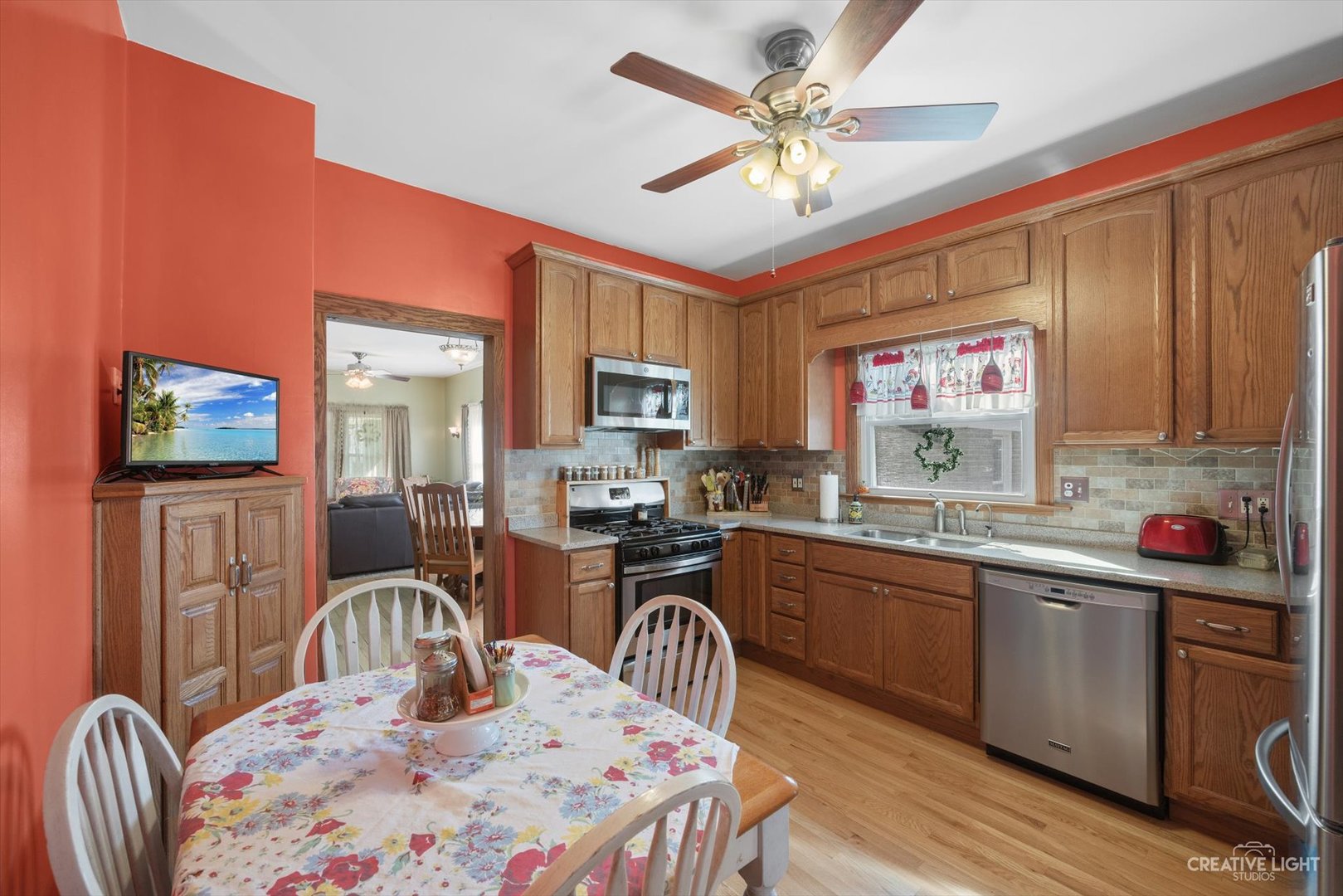 4534 Deyo Avenue Brookfield, IL 60513 - Photo 6 of 17 a kitchen with stainless steel appliances granite countertop a sink a stove a dining table and chairs with wooden floor