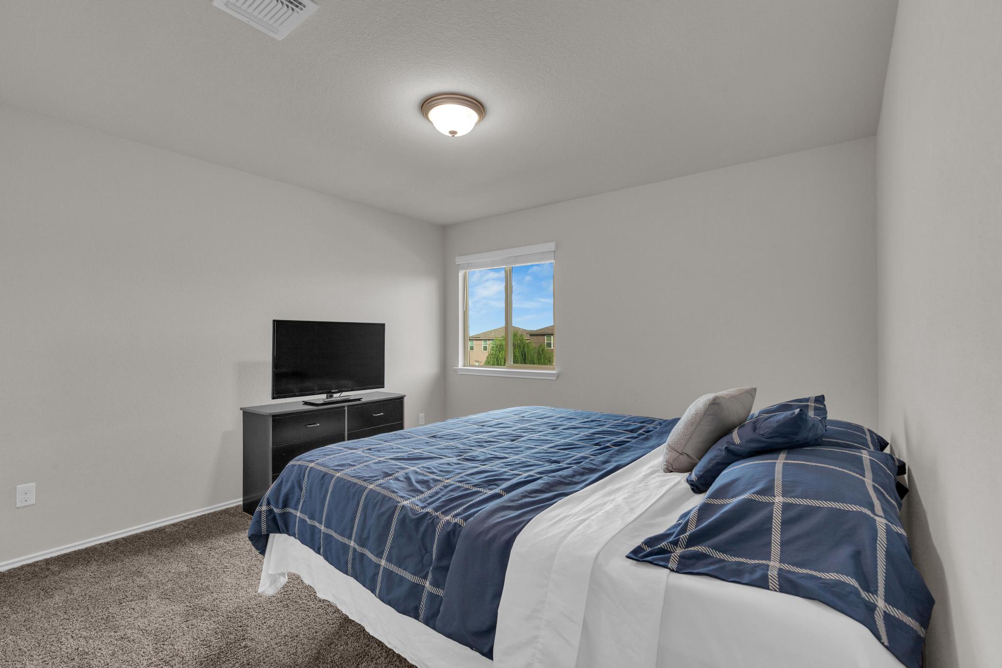 104 Uncle Billy Way Jarrell, TX 76537 - Photo 29 of 38 A well-lit bedroom provides comfortable living space with carpeted flooring and a window offering natural light.