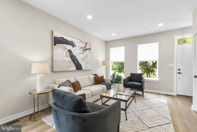 a living room with furniture and a view of kitchen
