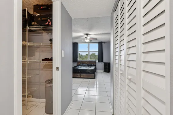 a view of a hallway to a livingroom with furniture and windows