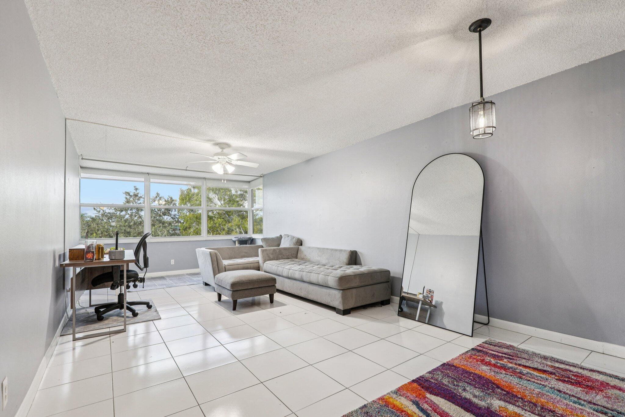 6500 Cypress Road, Unit 508 Plantation, FL 33317 - Photo 6 of 32 a living room with furniture and a floor to ceiling window