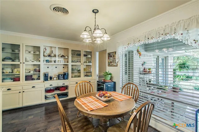 a dining room with furniture a chandelier and window
