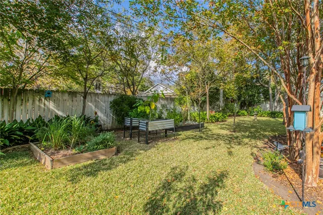 a view of a backyard with table and chairs under an umbrella