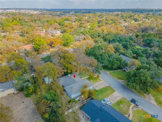 an aerial view of residential houses with outdoor space and swimming pool