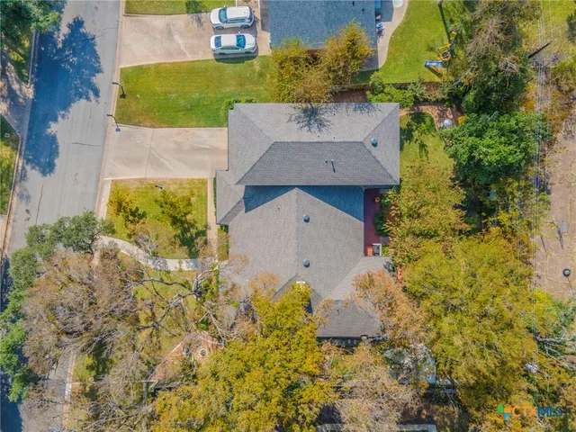a view of a house with backyard and a tree