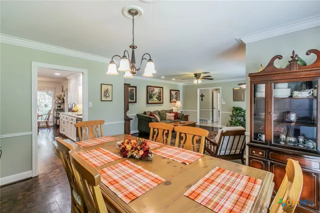 a view of a dining room with furniture a chandelier and wooden floor