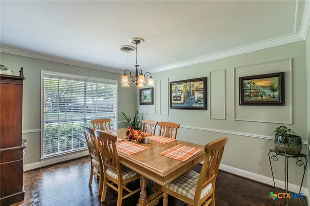 a view of a dining room with furniture wooden floor and a chandelier