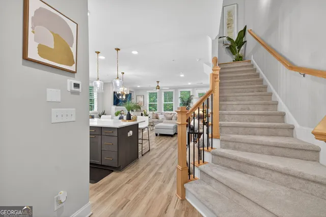 a kitchen with stainless steel appliances kitchen island granite countertop a dining table chairs and a refrigerator