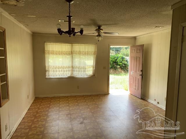 3281 Mason Road Walnut Hill, FL 32568 - Photo 24 of 41 a view of a room with wooden floor a ceiling fan and windows