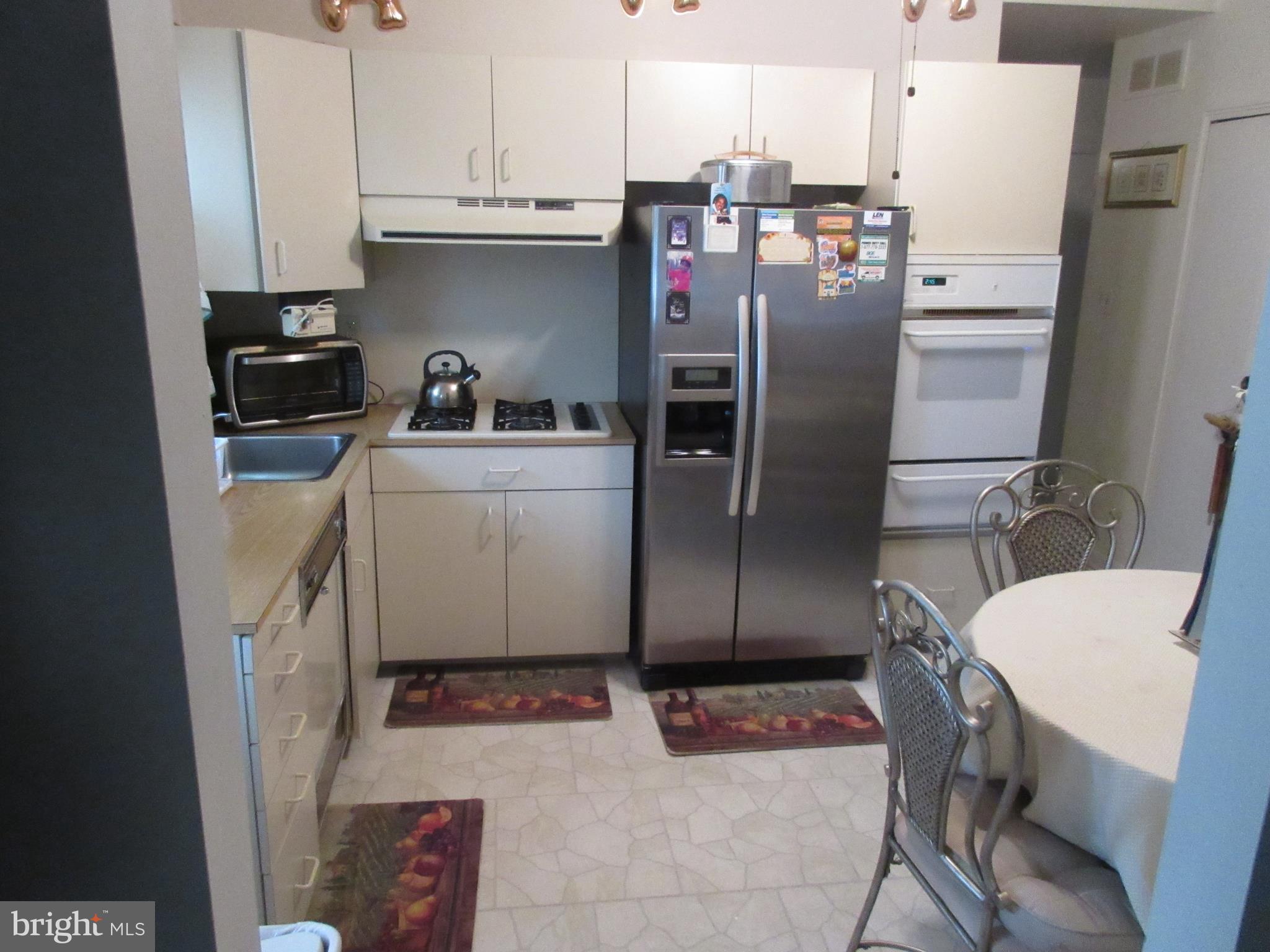 4786 Byron Road Baltimore, MD 21244 - Photo 9 of 30 a kitchen with stainless steel appliances a refrigerator a stove a sink and white cabinets