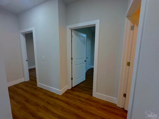 a view of a hallway with wooden floor