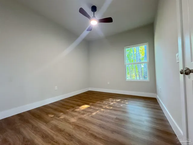 wooden floor in an empty room with a window
