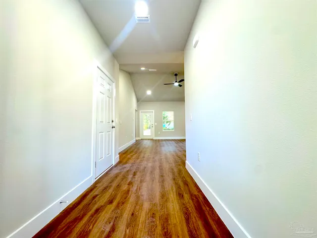 a view of a hallway with wooden floor