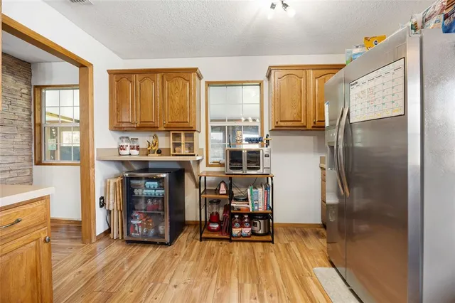a kitchen with stainless steel appliances a refrigerator and wooden floor