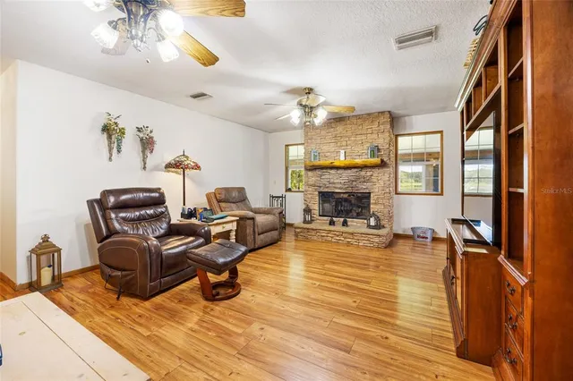 a living room with furniture a fireplace and a chandelier