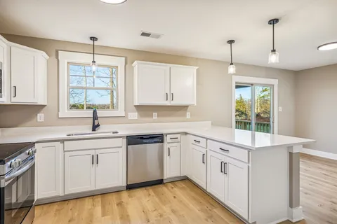 a kitchen with a sink window and cabinets