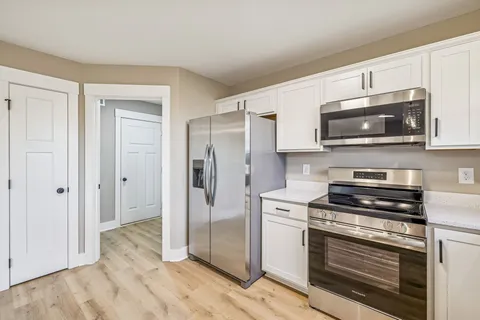 a kitchen with stainless steel appliances granite countertop a stove microwave and refrigerator