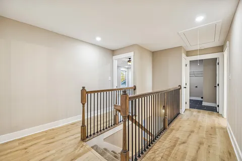 a view of a hallway with wooden floor and closet
