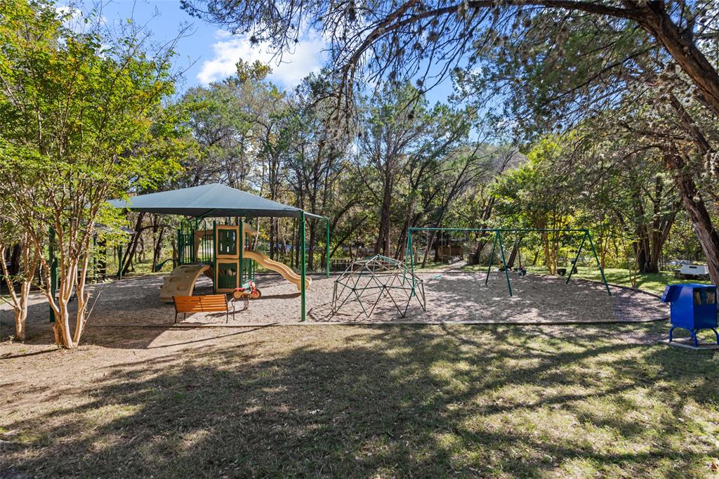 2210 Red Fox Road Austin, TX 78734 - Photo 39 of 40 A vibrant community playground with diverse equipment nestled under the shade of mature trees.