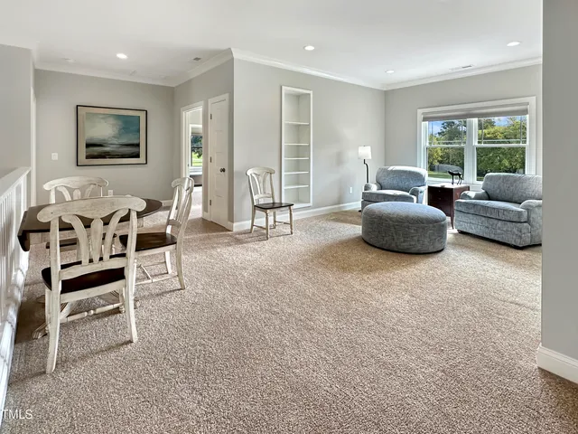 a living room with stainless steel appliances furniture and a kitchen view
