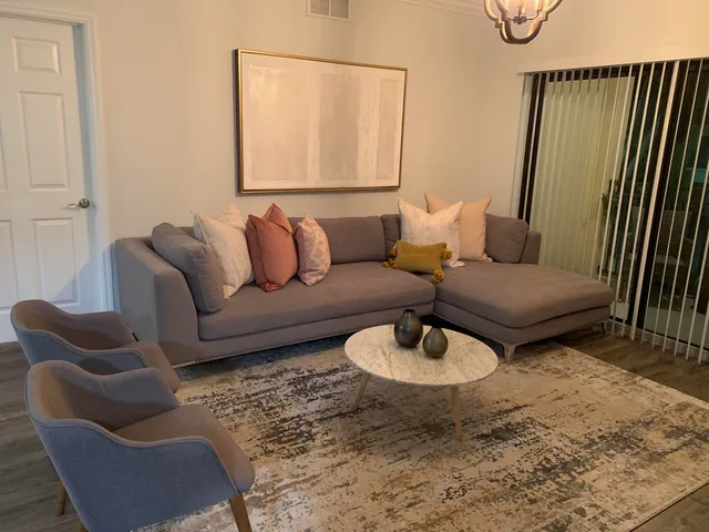 a living room with furniture rug and wooden floor