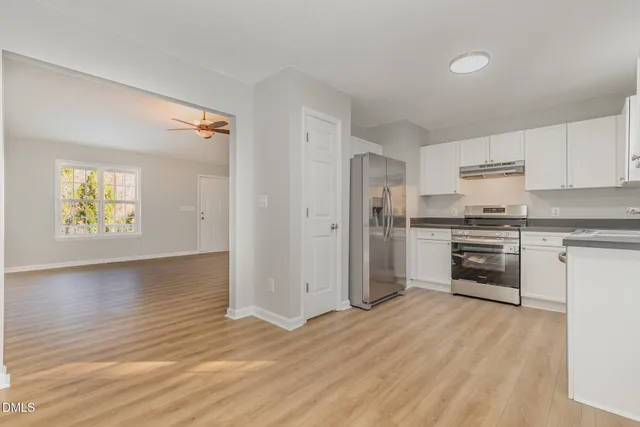 a kitchen with stainless steel appliances granite countertop a stove and white cabinets