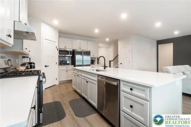 a living room with furniture a flat screen tv and kitchen view