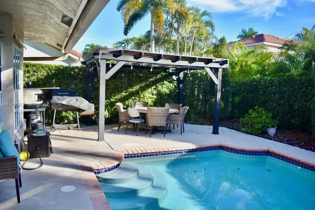 a roof deck with table and chairs and potted plants