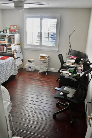 a bedroom with a bed and wooden floor