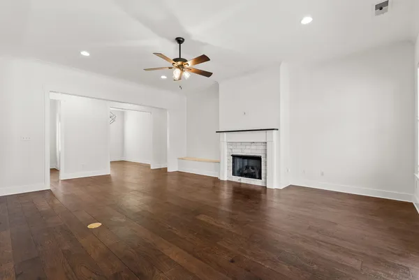 a view of an empty room with window and wooden floor