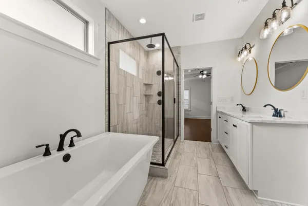 a spacious bathroom with a double vanity sink a mirror and a shower