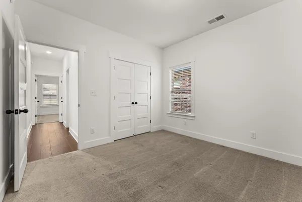 an empty room with windows and closet