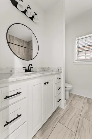 a bathroom with a sink mirror and toilet