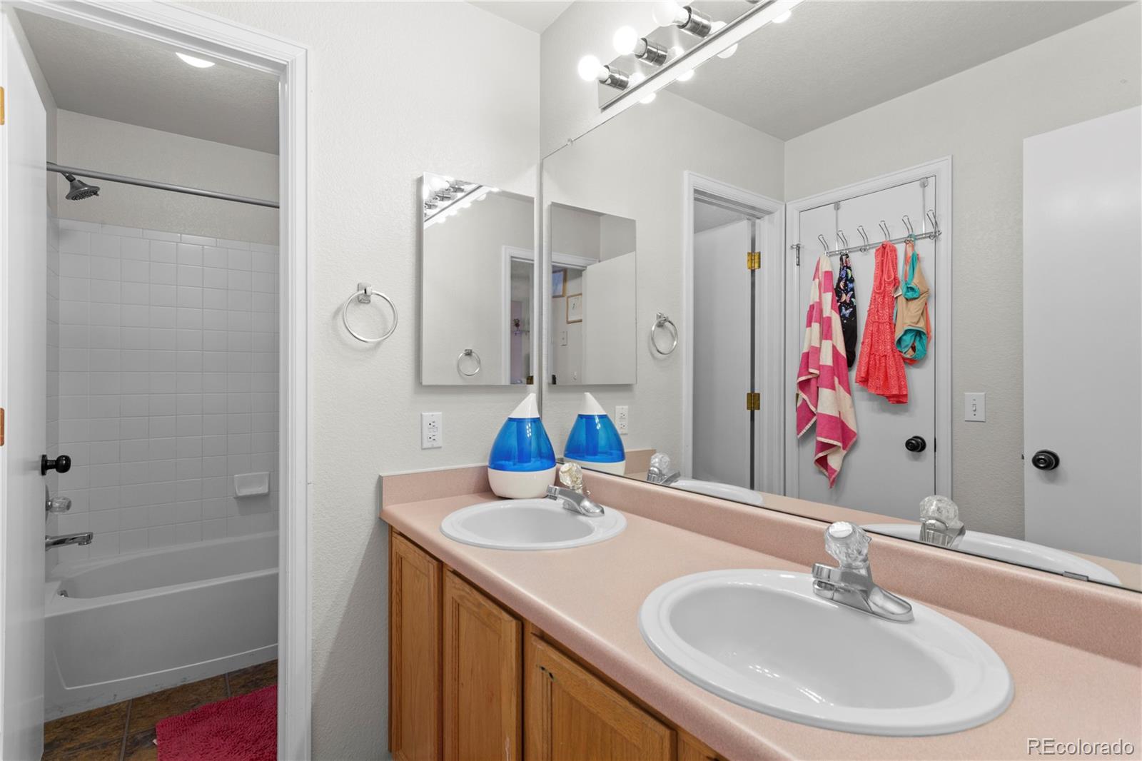 2212 Hyacinth Road Littleton, CO 80129 - Photo 28 of 44 a bathroom with a sink a vanity and a mirror