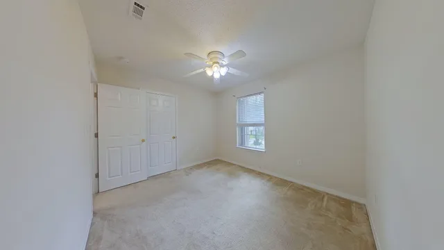 a view of room with a ceiling fan and window