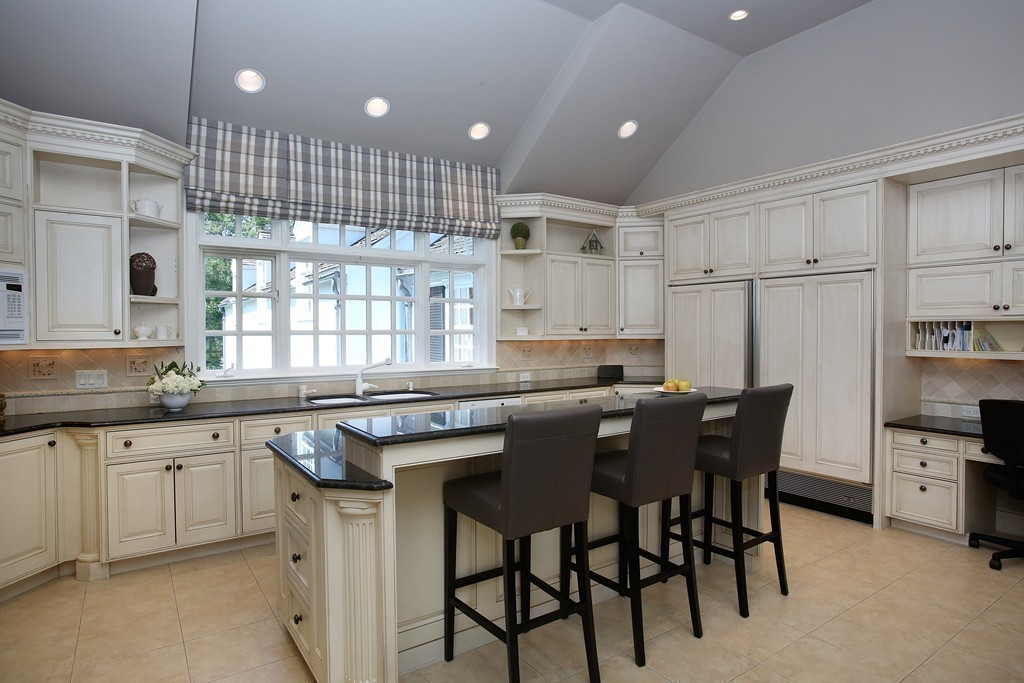 466 Glen Road Weston, MA 02493 - Photo 16 of 27 a kitchen with kitchen island granite countertop a table chairs sink and cabinets