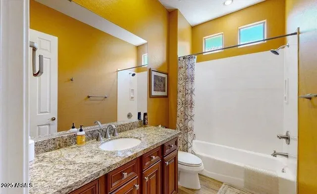 a bathroom with a granite countertop tub sink and mirror