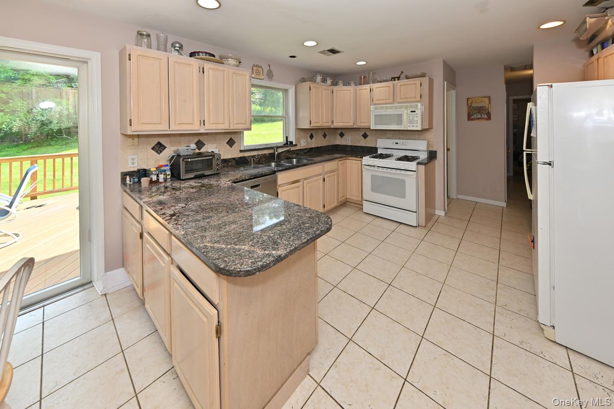 14 Roble Road Suffern, NY 10901 - Photo 11 of 30 Kitchen featuring white appliances, light tile patterned flooring, a peninsula, light brown cabinets, and recessed lighting