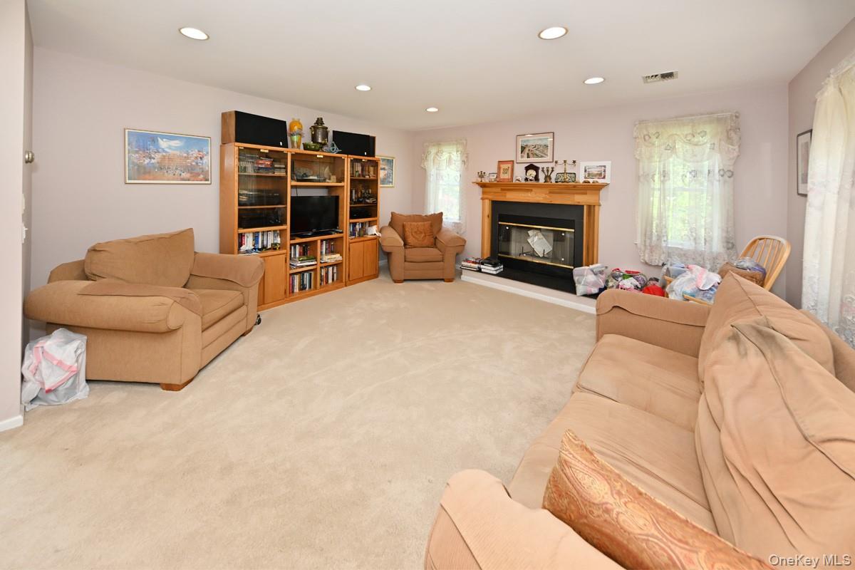14 Roble Road Suffern, NY 10901 - Photo 17 of 30 Living area with carpet floors, recessed lighting, and a glass covered fireplace